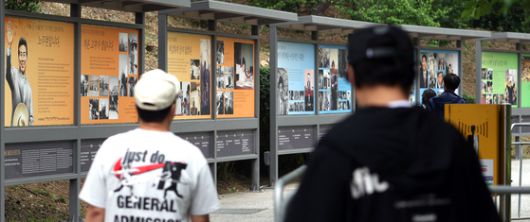 노무현 전 대통령 서거 16주기 추도식을 하루 앞둔 22일 경남 김해시 진영읍 봉하마을에서 시민이 노 전 대통령 사진을 보고 있다. 연합뉴스