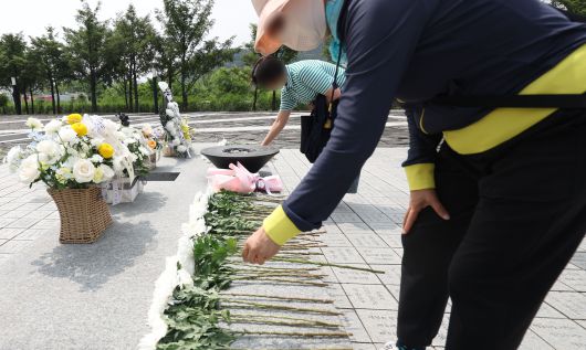 노무현 전 대통령 서거 16주기 추도식을 하루 앞둔 22일 경남 김해시 진영읍 봉하마을에 시민이 헌화하고 있다. 연합뉴스