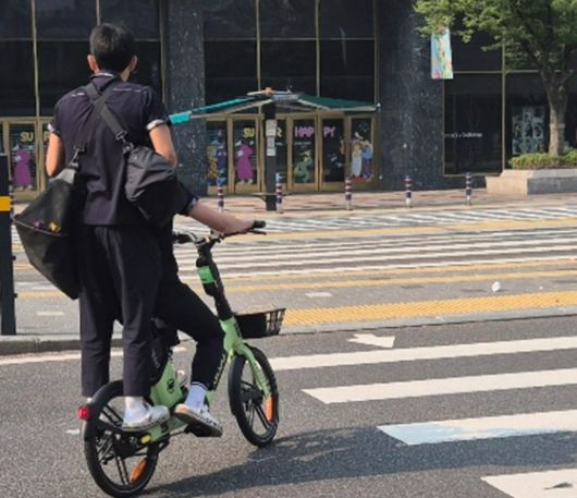 28일 오전 8시쯤 부산 서면에서 부산시가 투입한 비상 전세버스를 기다리던 고교생들이 공유형 자전거를 타고 등교하고 있다. 김민주 기자