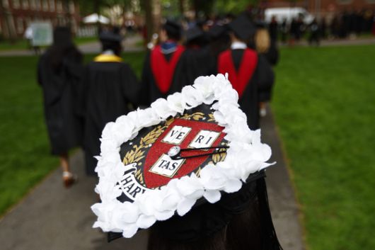 미국 매사추세츠주 케임브리지 하버드대에서 졸업식이 열린 29일(현지시간) 한 졸업생이 외국인 학생에 대한 지지와 연대의 표시로 흰 꽃을 학사모에 장식한 채 걸어가고 있다. EPA=연합뉴스