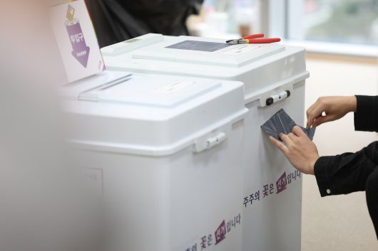제21대 대통령선거 사전투표 둘째 날인 30일 서울 중구 을지누리센터에 마련된 사전투표소에서 선거관리관이 투표함 특수봉인지를 제거하고 있다. 연합뉴스