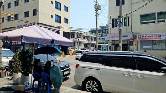 30일 서울 영등포구의 한 사전투표소 앞에서 그늘막을 설치한 남녀 2명이 '선거 감시' 명목으로 사전투표소를 오가는 유권자를 촬영했다. 이들은 ″사전투표가 조작됐다고 의심된다″고 주장했다. 이찬규 기자