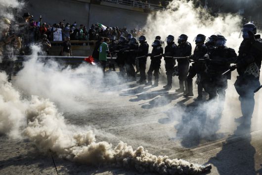 현지시간 8일 캘리포니아주 로스앤젤레스 연방 건물 밖에서 경찰이 시위대를 향해 비살상용 탄을 발사하고 있다. AFP=연합뉴스