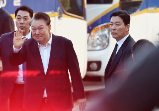 윤석열 전 대통령이 지난 3월 8일 오후 경기 의왕시 서울구치소에서 법원의 구속취소 결정으로 풀려난 가운데 지지자들에게 인사하고 있다. 오른쪽은 김성훈 전 대통령 경호처 차장. 뉴스1