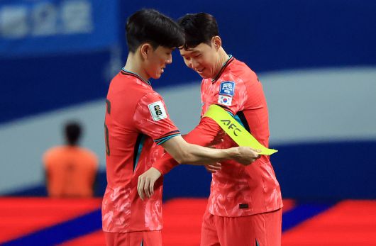 황인범에게 주장완장을 넘겨 받는 손흥민(오른쪽). [뉴스1]