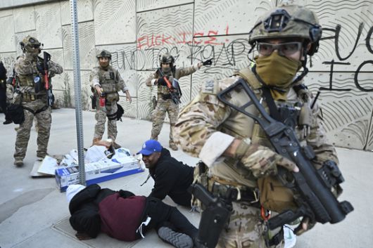 미국 세관국경보호국 요원들이 12일(현지시간) 로스앤젤레스에서 시위대를 해산시키고 있다. AP=연합뉴스