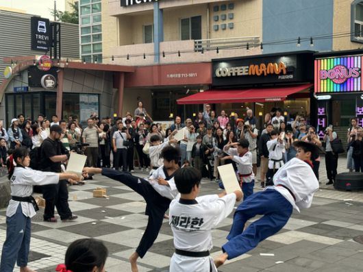 지난 8일부터 11일까지 3박 4일간 '제주와 함께하는 마음의 고향 여행'에 나선 입양인들이 제주시 연동 누웨마루거리에서 태권도 퍼포먼스를 관람하고 있다. 사진 제주관광공사