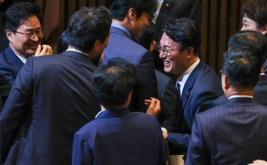 김민석 국무총리 후보자가 지난 5일 서울 여의도 국회 본회의장에서 더불어민주당 의원들의 '셀카' 요청을 받으며 웃고 있다. 뉴스1