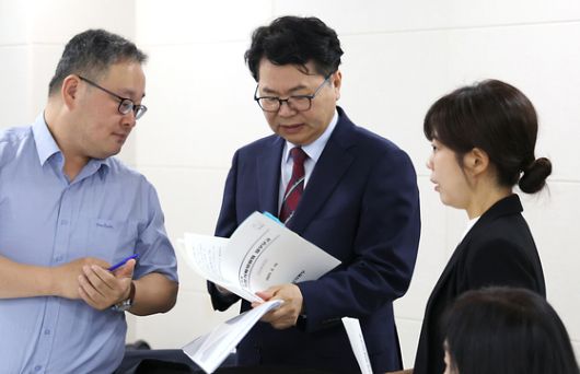 이한주 국정기획위원회 위원장(가운데) 19일 오전 세종시 정부세종컨벤션센터에서 열린 국정기획위원회 산업통상자원부 업무보고에 참석하며 관계자들과 업무보고 자료를 보고 있다. 뉴스1