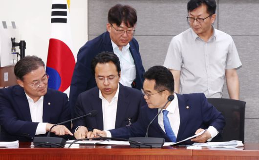 더불어민주당 을지로위원회 민병덕 위원장(앞줄 오른쪽)과 김범석 우아한형제들 대표(가운데)가 19일 오전 서울 여의도 국회에서 배달앱(배달의민족) 사회적대화기구 중간합의문 발표 브리핑에서 중간합의문에 서명하고 있다. 뉴스1