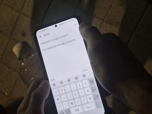 19일 밤 8시50분 러닝 순찰대원이 러닝 앱 '런 데이'에 부서진 보행로 시설물 현황을 사진과 함께 120에 신고하는 모습. 오소영 기자