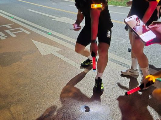 19일 오후 8시30분쯤 서울 강남구 잠원한강공원 보행로에서 경광봉 후레쉬 기능을 켜고 포트홀을 촬영하는 러닝 순찰대의 모습. 오소영 기자