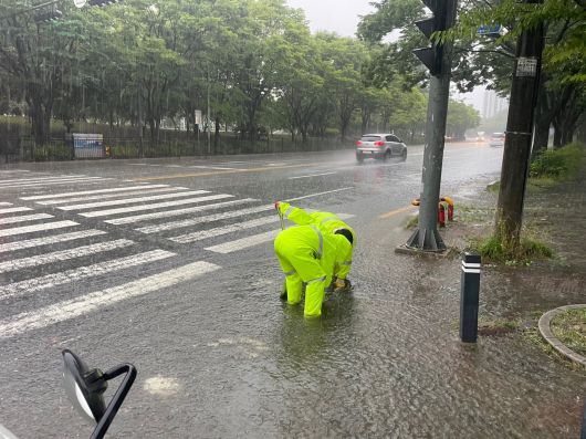 21일 광주 광산구 첨단2동에서 광산구 관계자들이 폭우로 이탈한 맨홀 뚜껑을 정비하고 있다. 사진 광주광산구