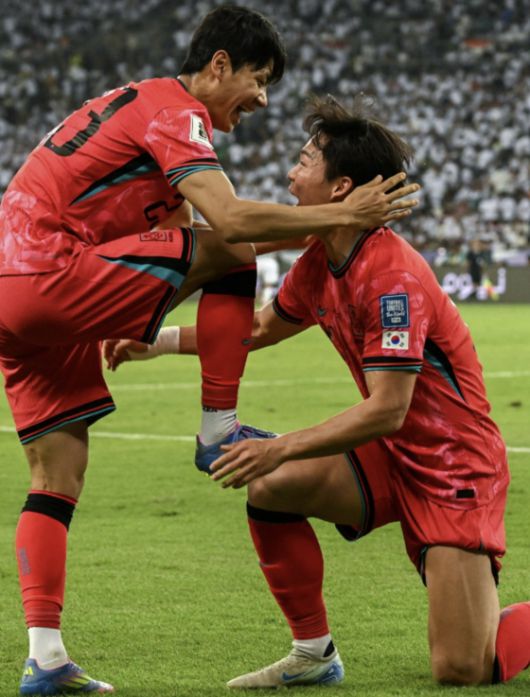 이라크전에서 전진우(왼쪽)와 ‘축구화 닦기’ 세리머니를 재연한 오현규. [AFP=연합뉴스]