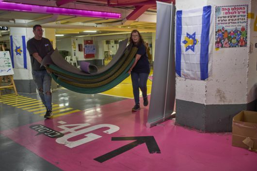 이스라엘과 이란의 휴전이 시작된 24일(현지시간) 텔아비브의 한 방공호에서 이스라엘 시민들이 매트리스를 정리하고 있다. AP=연합뉴스