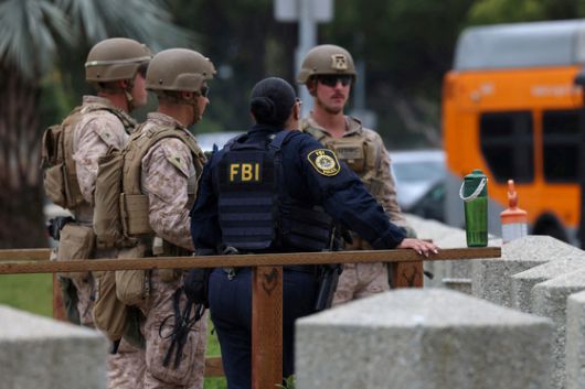 지난 20일(현지시간) 미국 캘리포니아주 로스앤젤레스에서 미국 부통령 J.D. 밴스의 방문을 앞두고 FBI 요원과 미 해병대가 윌셔 연방 건물 앞에서 경비를 서고 있다. 로이터=연합뉴스