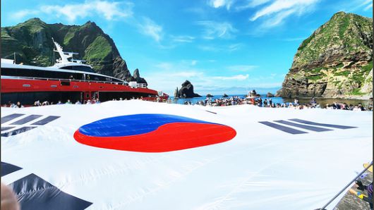 광복 80주년을 맞아 지난 28일 시민 80명이 독도 동도 선착장에서 가로 30m, 세로 20m 크기의 초대형 태극기를 펼치고 있다. 사진 서경덕 교수 SNS 캡처
