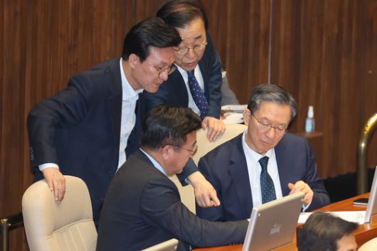 2019년 12월 10일 당시 홍남기 경제부총리 겸 기획재정부 장관이 국회 본회의장에서 자신의 의원석으로 가려고 일어선 유은혜 사회부총리 겸 교육부 장관과 대화하고 있다. 연합뉴스