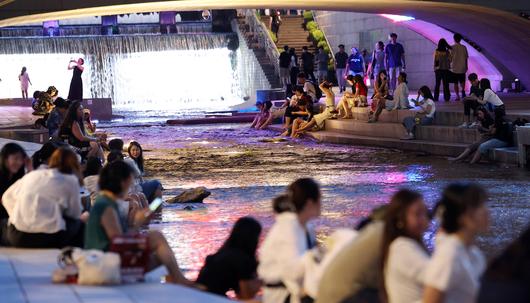 서울에 올해 처음으로 열대야가 기록된 지난달 30일 서울 청계천에서 시민들과 외국인 관광객들이 더위를 식히고 있다. 뉴스1