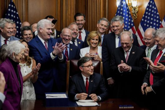 마이크 존슨 하원의장이 3일(현지시간) 공화당 의원들에게 둘러싸인 가운데 도널드 트럼프 대통령의 세금 감면 및 지출 삭감 법안에 서명하고 있다. AP=연합뉴스