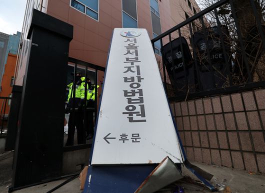 내란 우두머리 혐의를 받는 윤석열 대통령이 구속된 지난 1월 19일 오전 격분한 윤 대통령 지지자들의 난입 사태가 발생한 서울 마포구 서울서부지방법원 후문에 서부지법 현판이 파손된 채 놓여 있다. 뉴스1