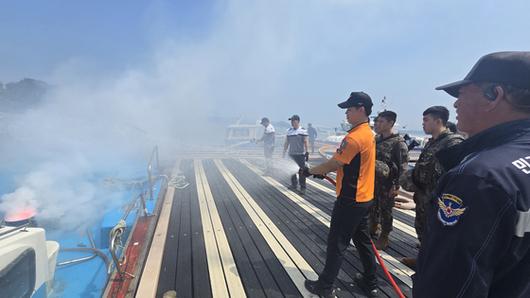 7일 오전 충남 태안군 영목항에서 열린 선박 화재 진압 훈련에서 119소방대와 해경이 호스를 이용해 불을 끄고 있다. 신진호 기자