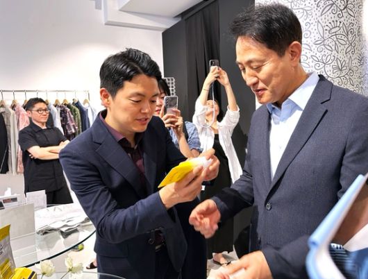 오세훈 서울시장이 이탈리아 밀라노에서 한국 기능성 화장품 사용을 권유받고 있다. 밀라노(이탈리아)=문희철 기자