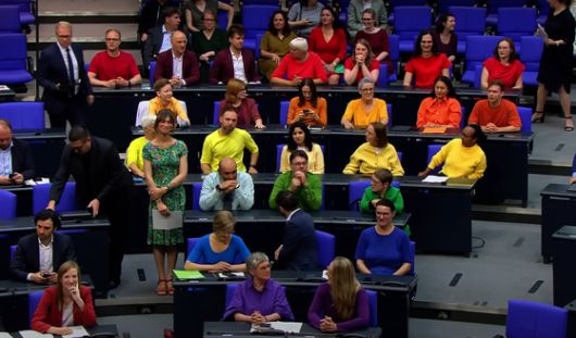 독일의 녹색당과 좌파당 소속 의원들이 지난달 26일(현지시간) 연방하원 본회의장에서 빨강, 주황, 노랑 등 무지개 색의 티셔츠를 입고 퀴어축제인 크리스토퍼 스트리트 데이’(CSD)에 무지개 깃발을 계양하지 않기로한 율리아 클뢰크너 연방하원 의장의 결정을 비판하고 있다. 독일 ntv 캡처