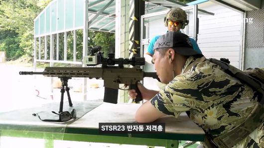 기자가 STSR23 반자동 저격총을 쏘고 있다. 화면 캡처