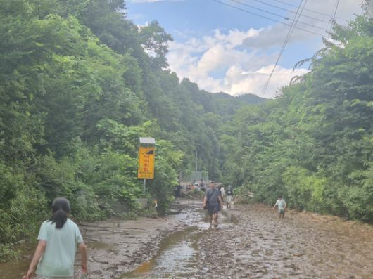 20일 매몰 사고가 발생한 경기도 가평군 조종면 캠핑장 입구에 토사와 강물에 휩쓸려 무너진 건물 잔해와 나무 더미가 쌓여있다. 진입로 겸 다리가 계곡물에 휩쓸려 떠내려가 포클레인 등 장비가 진입하지 못해 소방당국이 구조에 어려움을 겪고 있다. 가평=전율 기자