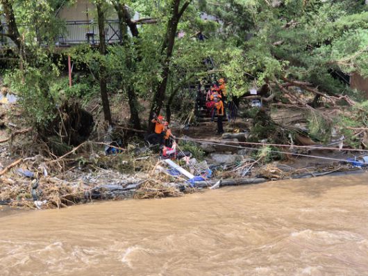 20일 오전 경기 가평군의 한 교육 시설에서 폭우로 고립돼 있던 학생들이 119 구조대와 탈출하고 있다. 연합뉴스