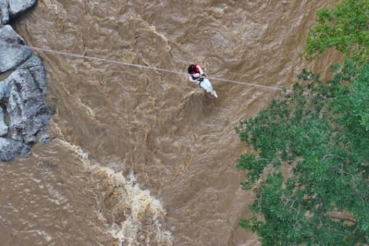 20일 경기도 가평군의 한 캠핑장에서 불어난 강물에 고립됐던 시민이 소방 로프를 타고 탈출하고 있다. [뉴스1]