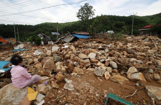 20일 경남 산청군 산청읍 외정마을의 한 주민이 돌밭으로 변한 마을을 바라보며 망연자실해 하고 있다. 지난 16일부터 ‘극한 호우’가 내린 산청군에서는 산사태와 침수가 잇따르고, 10명이 숨지고 4명이 실종되는 인명피해까지 발생했다. [뉴스1]