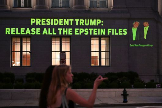 도널드 트럼프 미국 대통령(오른쪽)과 제프리 엡스타인의 사진과 함께 트럼프 대통령에게 엡스타인 스캔들과 관련된 파일을 모두 공개하라고 요구하는 문구가 투사되고 있다. AFP=연합뉴스