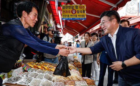 윤호중 행정안전부 장관이 24일 서울 금천구 비단길현대시장 시흥건어물을 찾아 민생회복 소비쿠폰 사용 현장을 점검하며 물건을 구매하고 있다. [사진 행정안전부공동취재단]