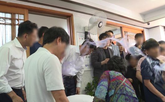 전주·완주 통합에 반대하는 완주군민에게 물벼락을 맞은 우범기 전주시장이 아무 말 없이 손수건으로 얼굴을 닦고 있다. 사진 독자