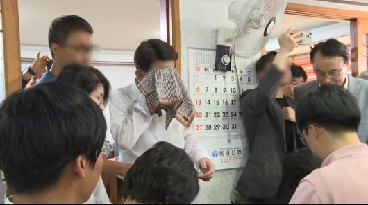 물벼락을 맞은 우범기 전주시장이 앞을 가로막는 통합 반대 측 주민들을 뚫고 관용차로 이동하고 있다. 사진 독자