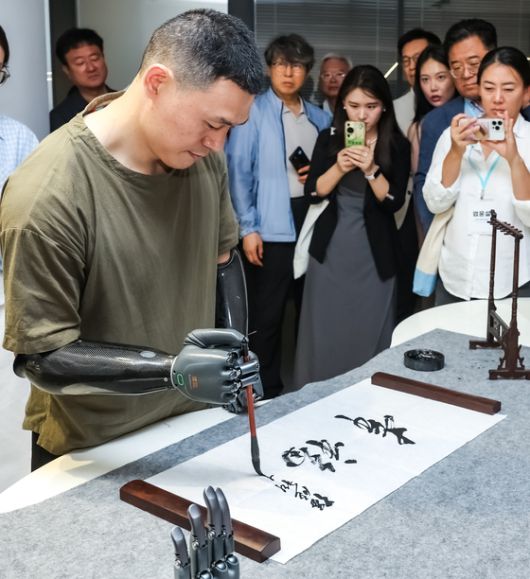 브레인코가 만든 바이오닉 핸드를 장착한 청년이 붓글씨를 쓰고 있다. 장진영 기자