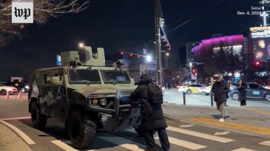 지난해 12월 3일 비상계엄 사태 당시 한 시민이 장갑차를 막아서고 있다. 워싱턴포스트 웹사이트 캡처