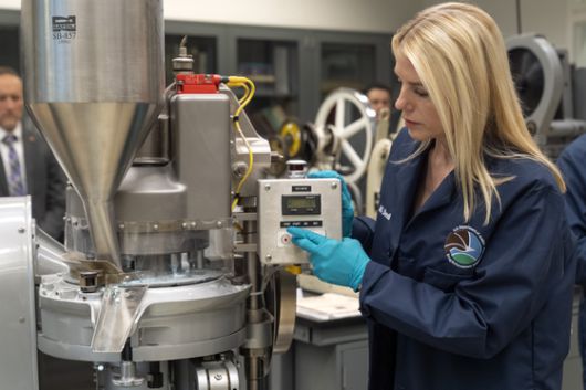 지난 4월 29일(현지시간) 미국 버지니아 북부의 마약단속국(DEA) 연구소에서 모의 펜타닐 정제를 제조하는 정제 프레스 기계를 작동하는 팸 본디 법무장관. AP=연합뉴스