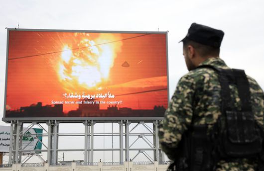 후티 반군 군인이 지난 29일 예멘 사나의 한 광고판 앞에서 경비를 서고 있다. EPA=연합뉴스