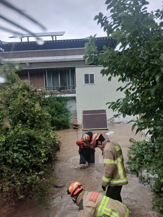 7일 오전 6시8분쯤 전주시 완산구 색장동 주택가가 물에 잠겨 소방대원들이 주민들을 미침수 지역으로 대피시키고 있다. 사진 전북특별자치도소방본부