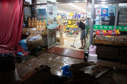 군산시 공무원들이 7일 새벽 기록적인 폭우로 침수 피해를 입은 나운동·문화동 일대에 급파돼 주민과 함께 쓰레기를 치우거나 배수 작업을 돕고 있다. 사진 군산시