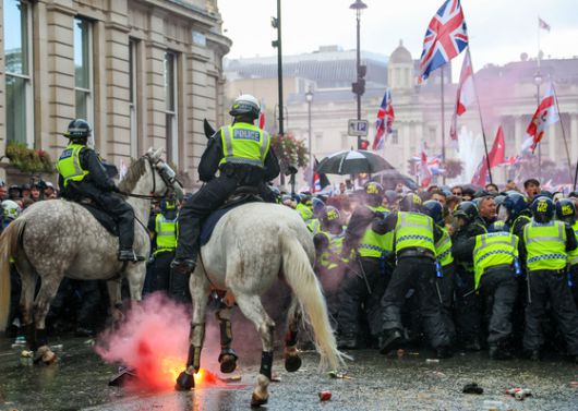 13일(현지시간) 영국 런던에서 집회 참석자들이 경찰에 의해 저지당하는 가운데 신호탄이 던져지고 있다. EPA=연합뉴스