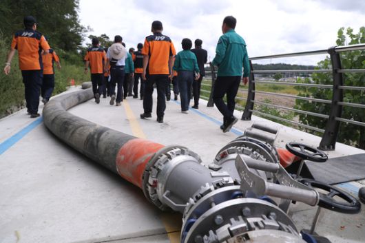 지난 12일 강원 강릉시 홍제동 남대천 임시 취수정 인근에 300㎜ 대구경 소방호스가 놓여 있다.   중앙119구조본부는 대용량포방사시스템에 300㎜ 대구경 소방호스를 연결해 약 1km 떨어진 홍제정수장까지 물을 직접 송수할 계획이다. [연합뉴스]