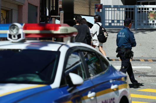 초등학교 인근 유괴 미수와 불법 촬영 사건 등으로 학부모들의 불안감이 확산하는 가운데 10일 오후 서울 서대문구의 한 초등학교 정문 앞에서 경찰관이 학생들의 하교를 지켜보고 있다. 뉴스1