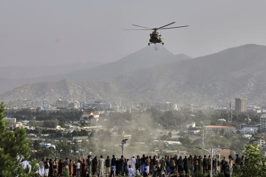 지난 8월 15일 아프가니스탄 수도 카불에서 열린 미국 철수 및 탈레반 통치 시작 4주년을 기념하는 행사에서 군용 헬리콥터가 도시 상공에 꽃을 떨어뜨리고 있다. AP=연합뉴스