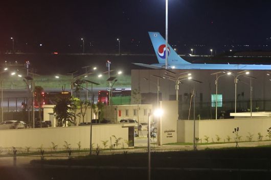 17일(현지시간) 캄보디아 프놈펜에 위치한 이민청에서 테초국제공항으로 이동하는 버스에 오르는 구금 한국인들의 목 부근에 숫자가 매겨진 종이가 붙어있다. 연합뉴스