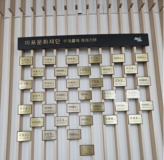 마포아트센터 아트홀맥(대극장). 로비 한쪽 벽면을 채운 34명의 객석 기부 명단. 왼쪽 하단에 ‘김민석’ 세 글자가 눈에 띄었다. 오는 29일 센터에서 열리는 테너 김민석의 ‘로맨틱 리사이틀’ 공연을 기념하기 위해 한 팬이 쾌척하며 붙여진 명패다. 센터는 2022년부터 기부금을 내면 객석(50만원), 로비(100만원)에 이름표를 부착하는 프로젝트를 진행하고 있다. 최민지 기자