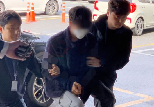 '야탑역 살인예고글'을 작성한 혐의로 체포된 20대 피의자가 지난해 11월 15일 오전 구속 전 피의자 심문(영장실질심사)을 마친 뒤 경기 수원남부경찰서로 호송되고 있다. 연합뉴스